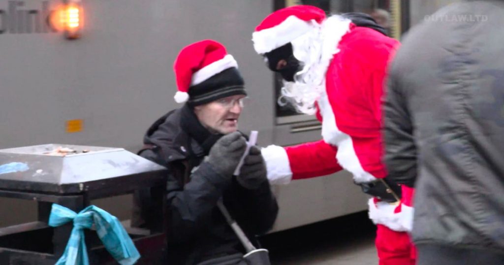 Un Mos Craciun mascat a oferit felicitari cu bancnote de 10 lire oamenilor strazii dar a fost arestat de politie